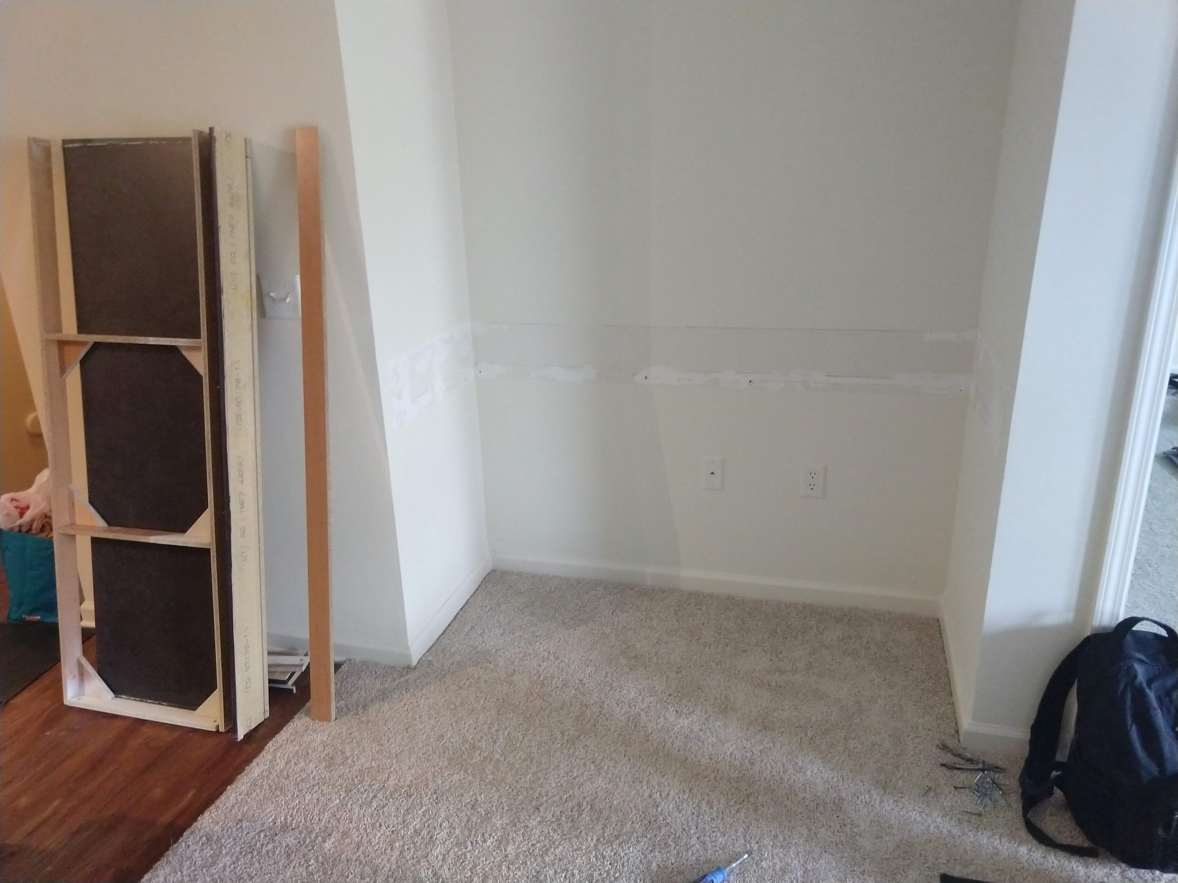 Photo of the same nook with the desk torn out, with some damage to the wall.