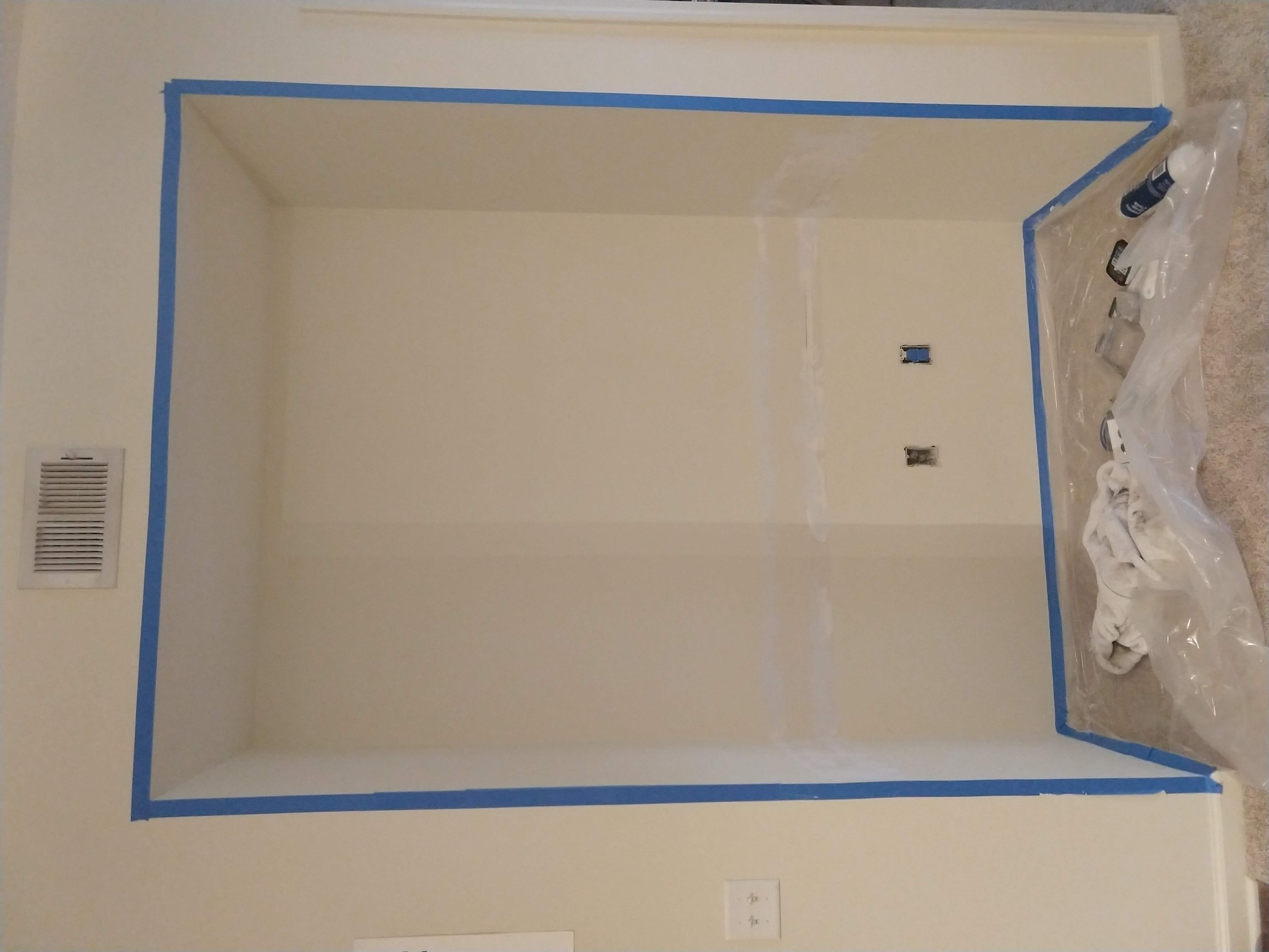 Photo of the nook with the wall damage filled in and prepped with painter&rsquo;s tape & plastic sheeting.