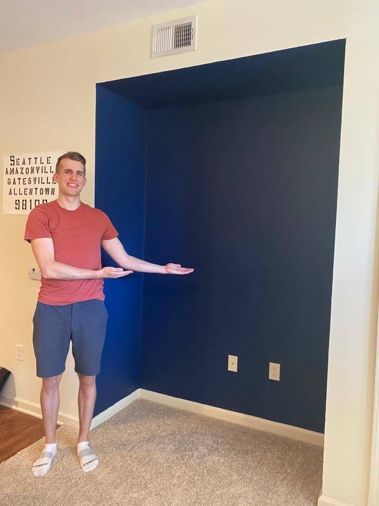 Photo of the author standign in front of the fully painted and cleaned up nook.