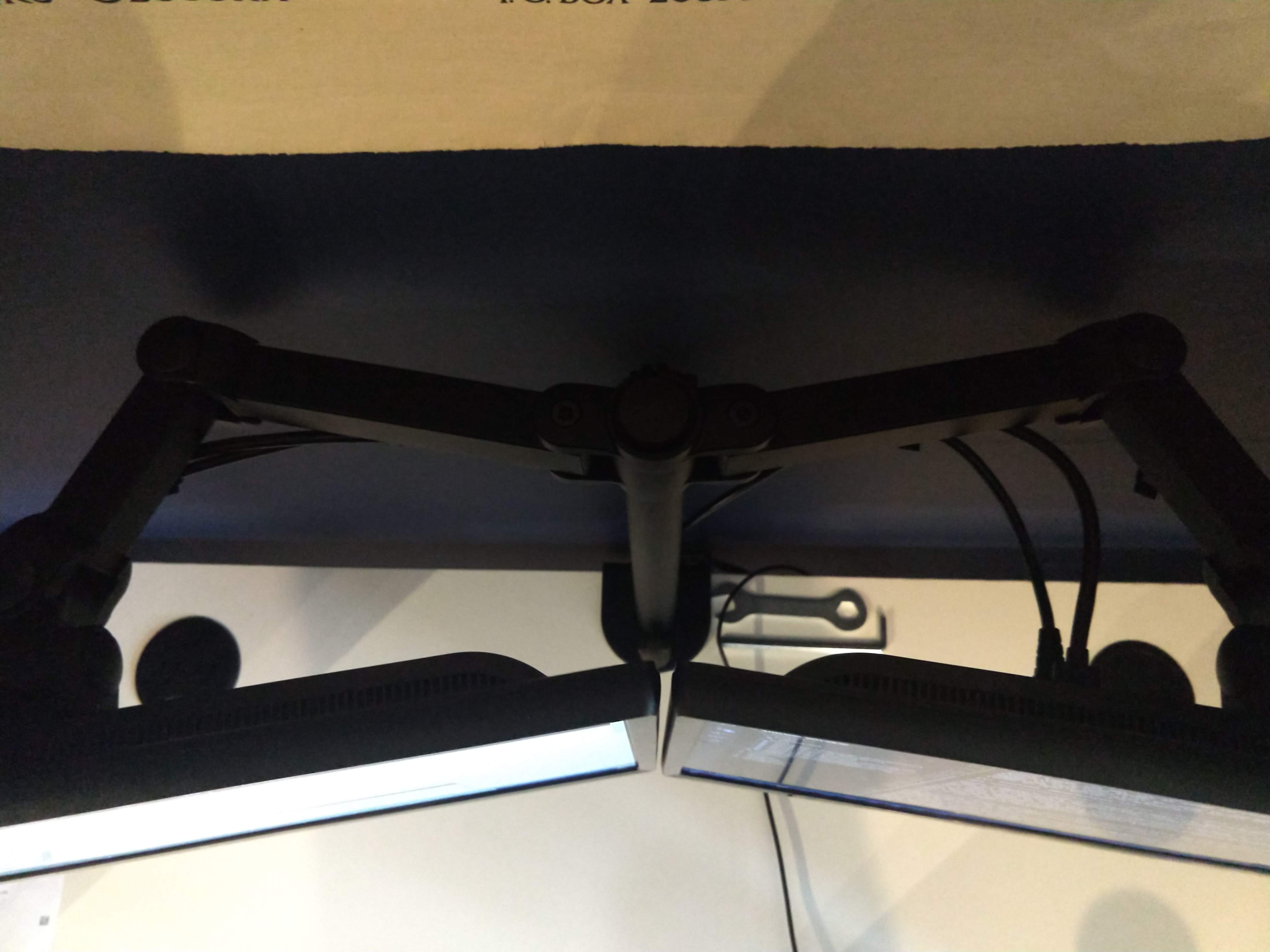 Overhead photo of the monitor arms and how much space they require behind them.