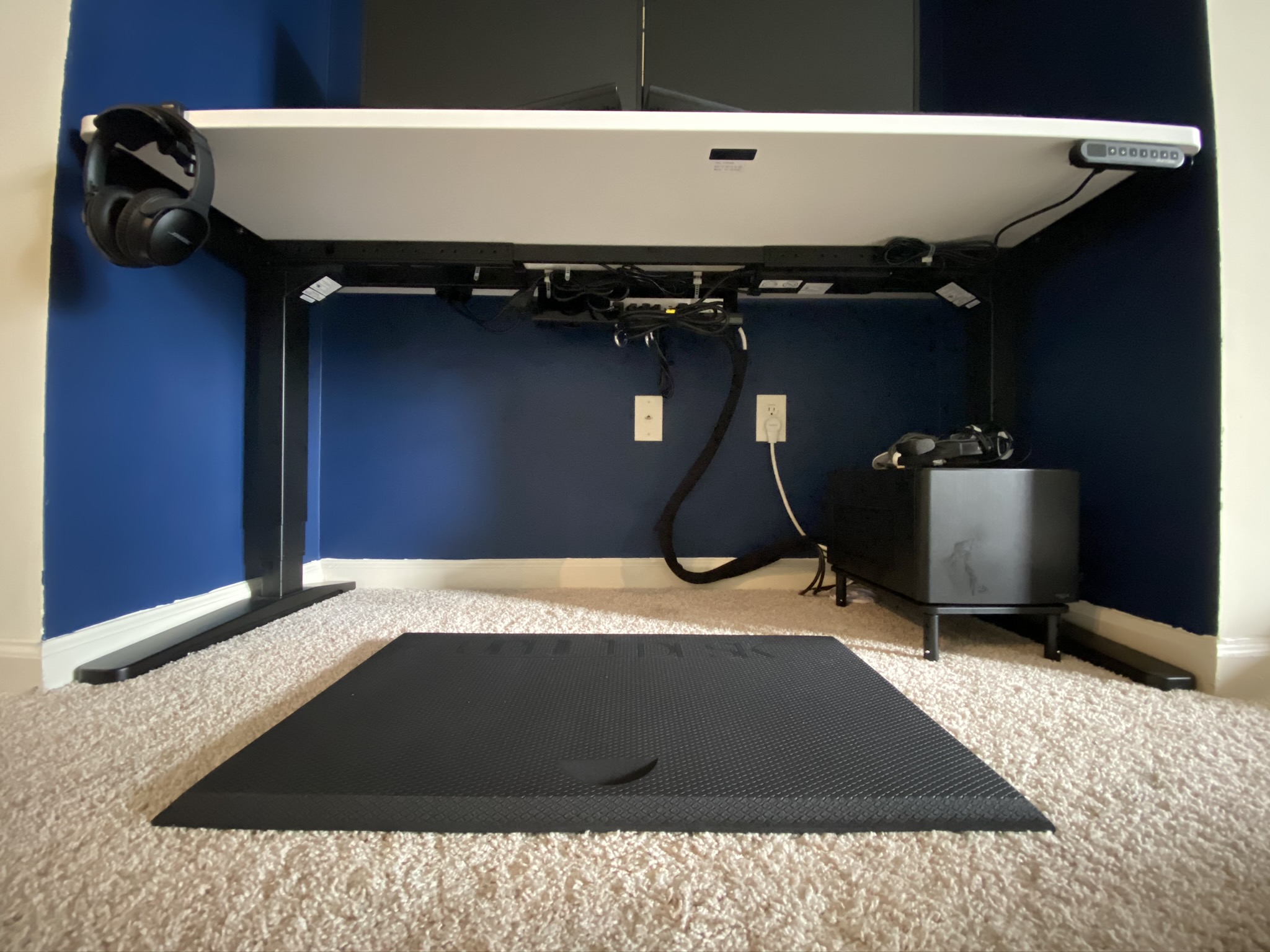 A white uplift desk viewed from below.